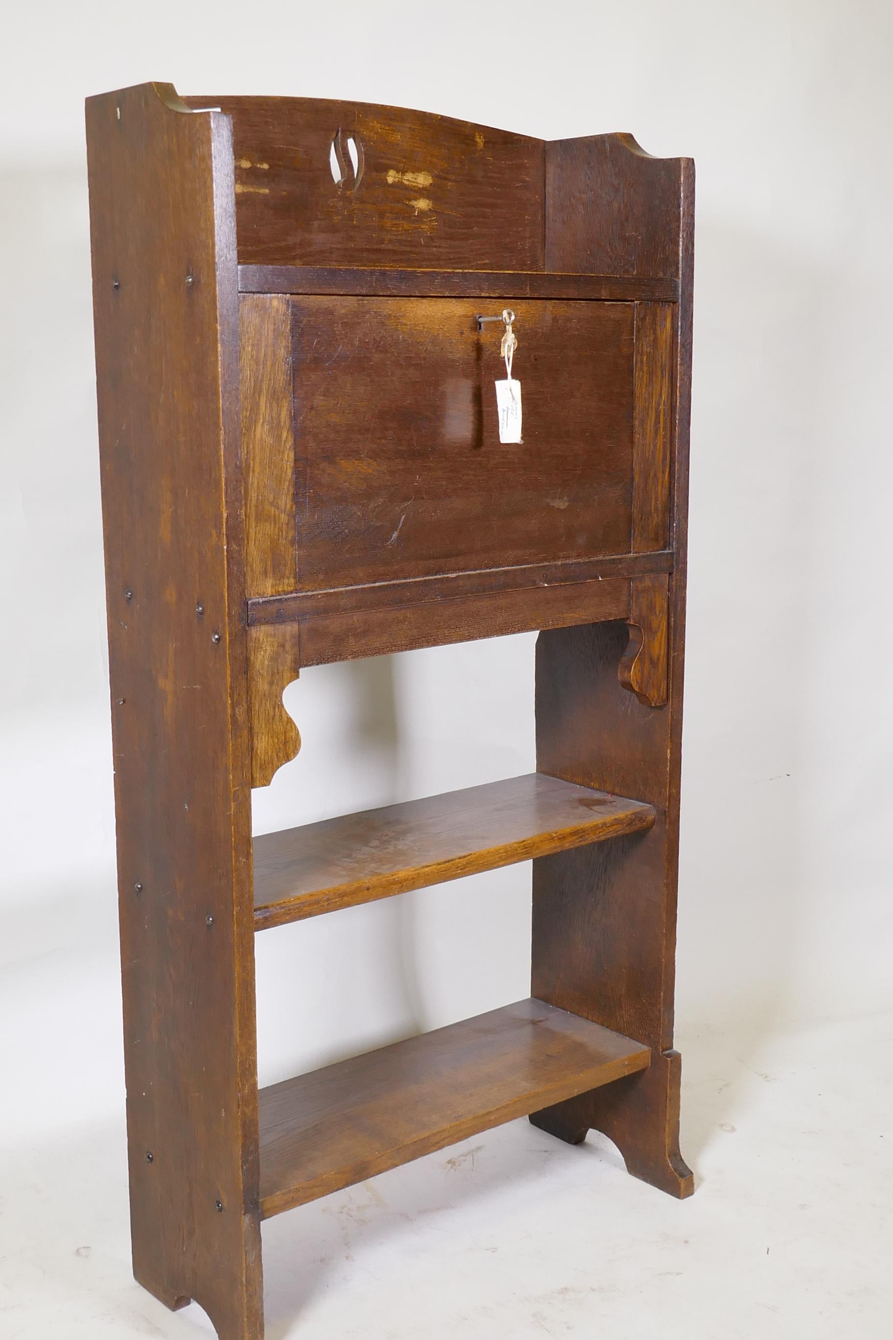 An Arts and Crafts oak bureau, with fall front and fitted interior over two open shelves, 61 x 22 - Image 2 of 2