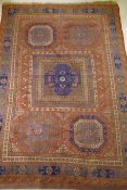 An antique Bergama carpet, with geometric designs on a terracotta coloured field and soft sheen to