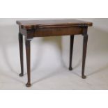A Georgian mahogany fold over tea table with inlaid games top, shaped top and frieze drawer,