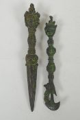 A Tibetan cast iron phurba with a wrathful deity mask handle, and a similar cast iron kartika,