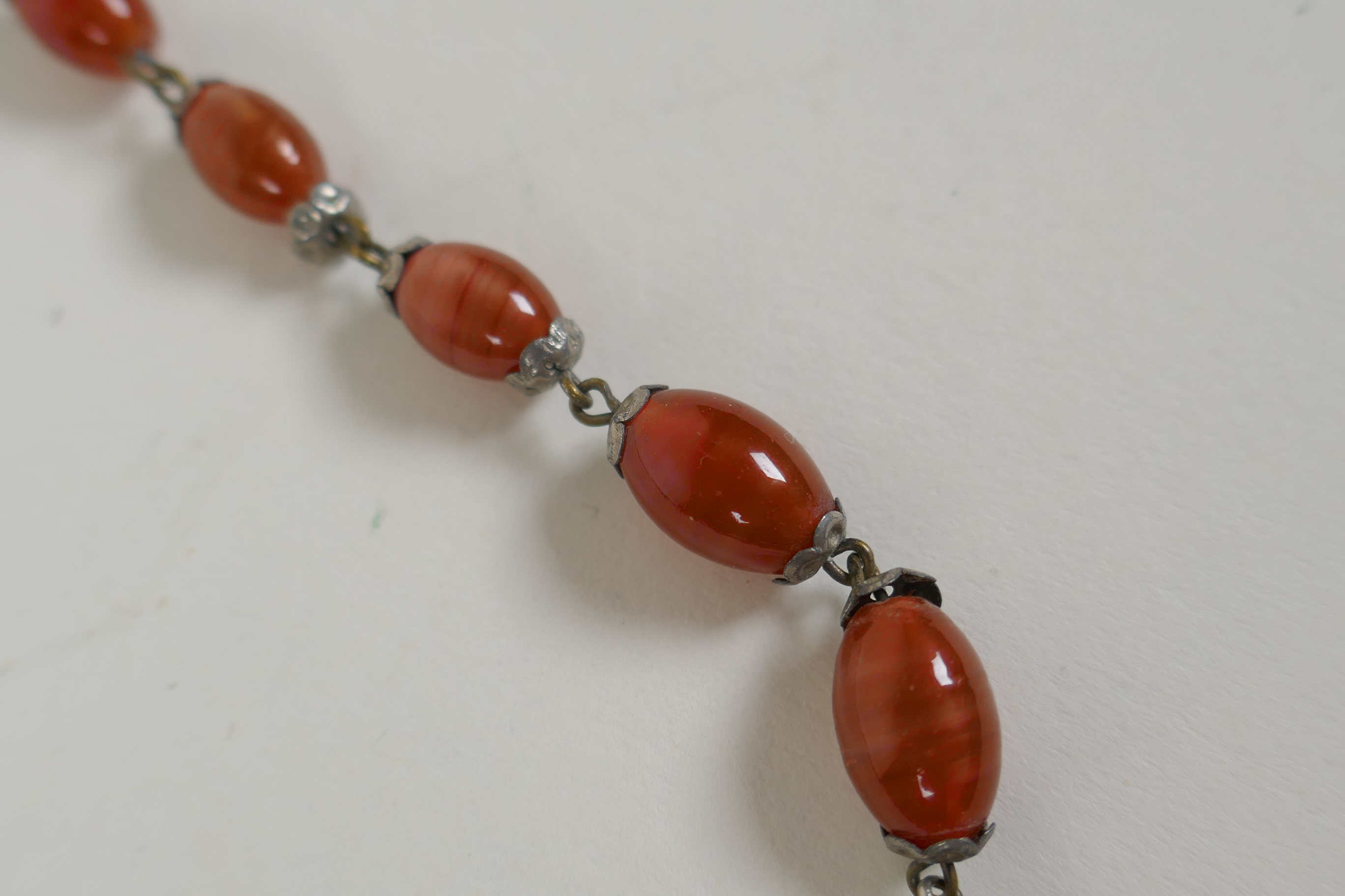 An antique graduated amber swirled glass necklace, 78cm long - Image 3 of 4