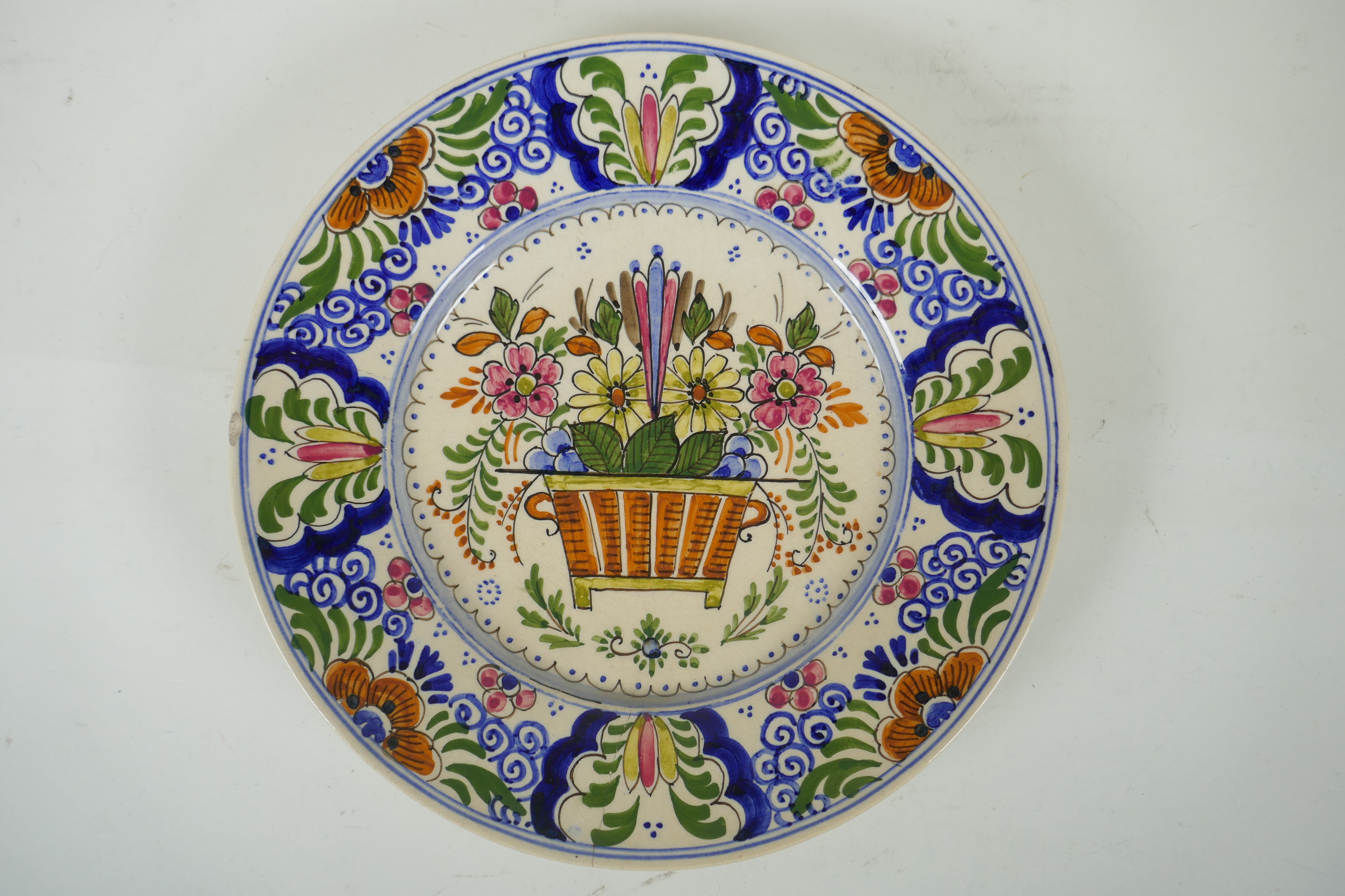 A polychrome Delft cabinet dish with floral decoration, mark to bae, AF, 25cm diameter