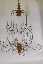 A wrought iron and pine six branch chandelier, with twelve candle prickets and glass lustre swags,
