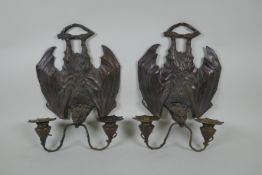 A pair of gothic style bronze two branch wall sconces in the form of bats, 24 x 33cm