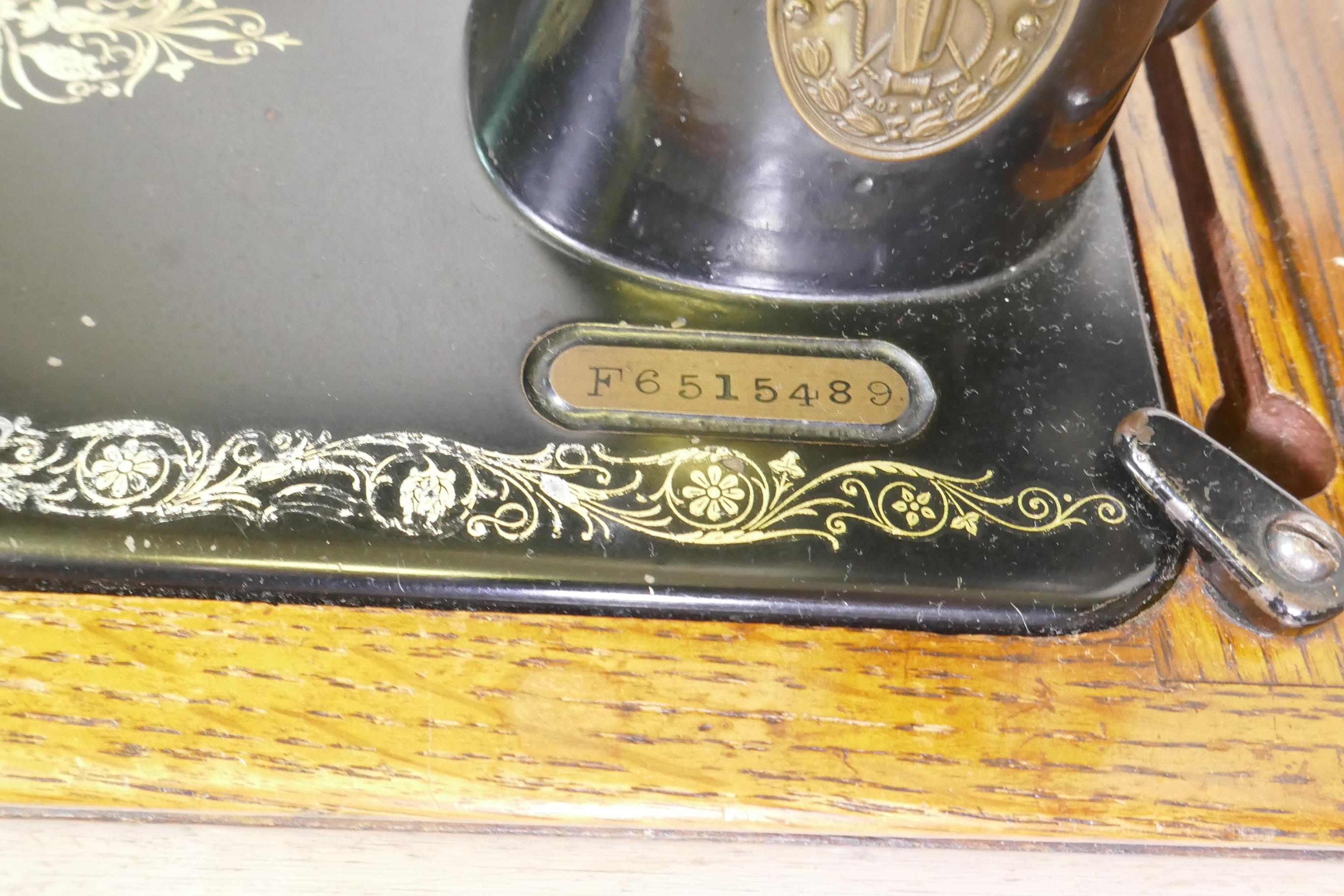 A Singer hand cranked sewing machine, No F6515489, in an oak case - Image 2 of 3