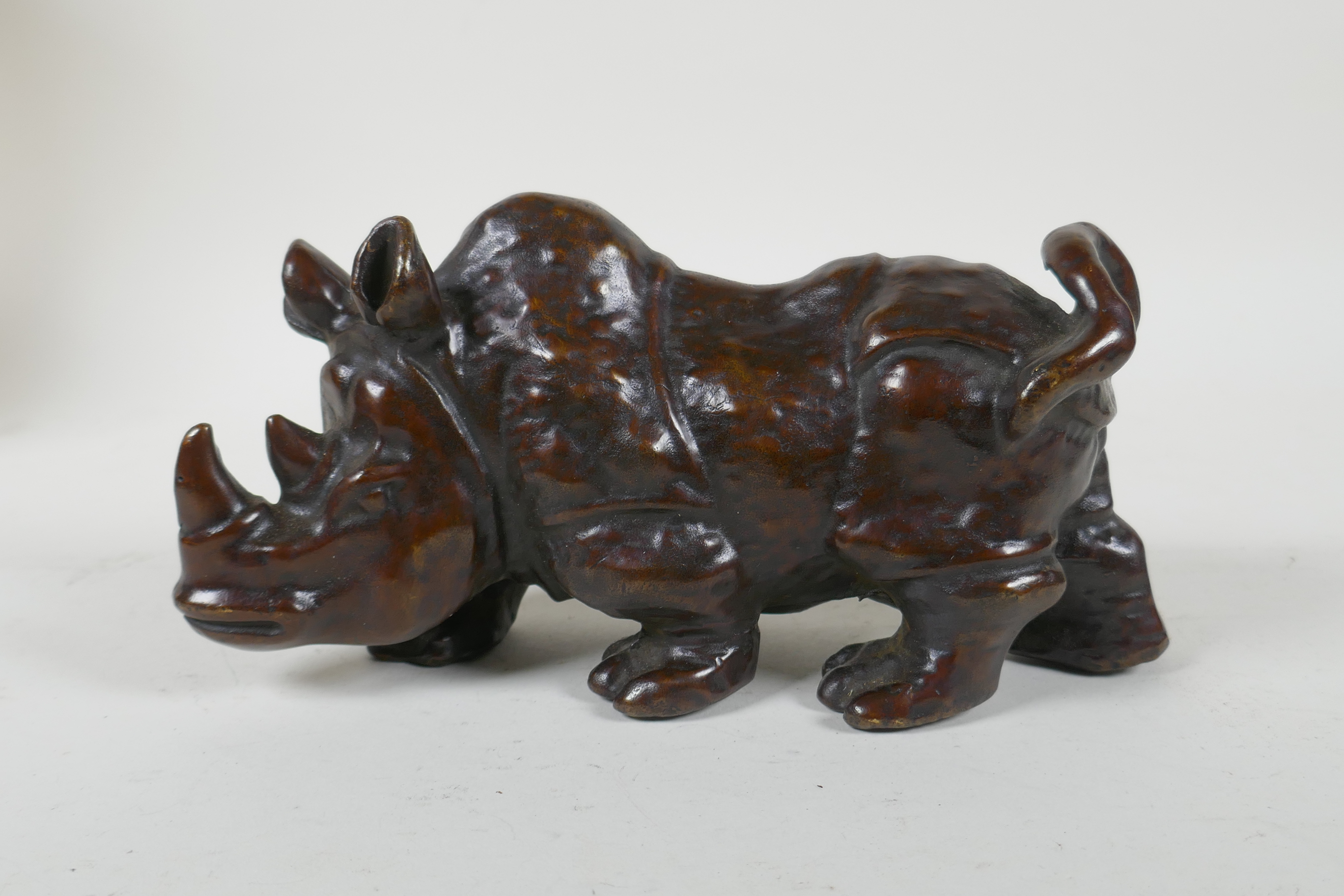 A filled bronze rhinoceros, 19cm long