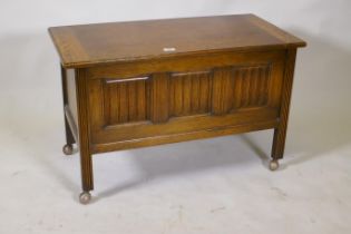 An oak triple panel  coffer with linen fold decoration, raised on reeded supports, 92 x 46 x 57cm