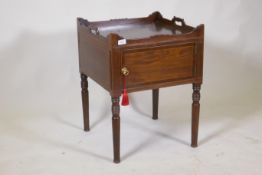 A Georgian mahogany pot cupboard, with carved galleried top, single door, raised on turned supports,