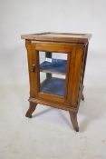 A small walnut vitrine with single door, raised on shaped supports with castors, 39 x 39 x 66cm