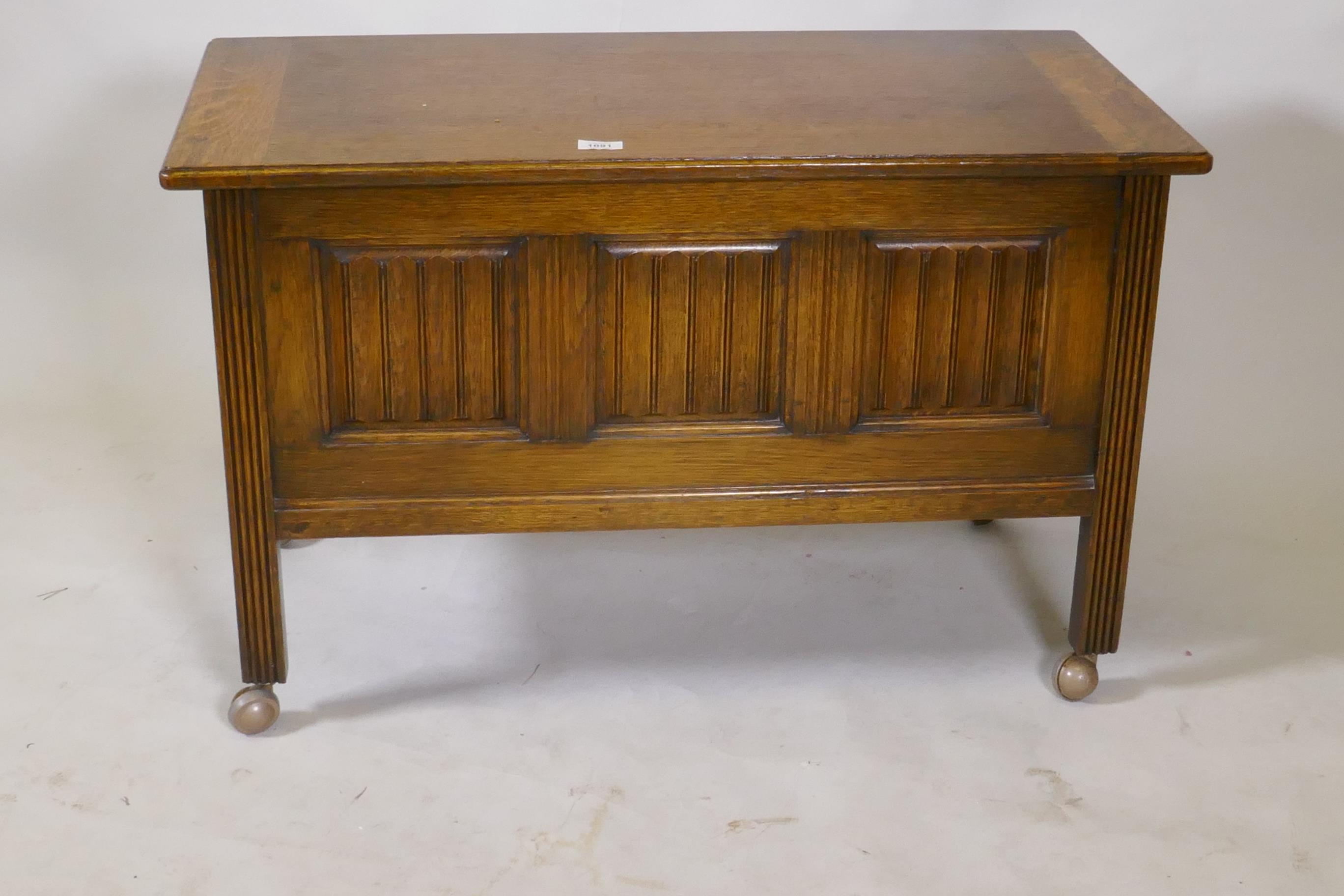 An oak triple panel  coffer with linen fold decoration, raised on reeded supports, 92 x 46 x 57cm - Image 2 of 2