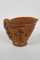 A Chinese faux horn libation cup with carved kylin decoration, seal mark to base, 10cm high
