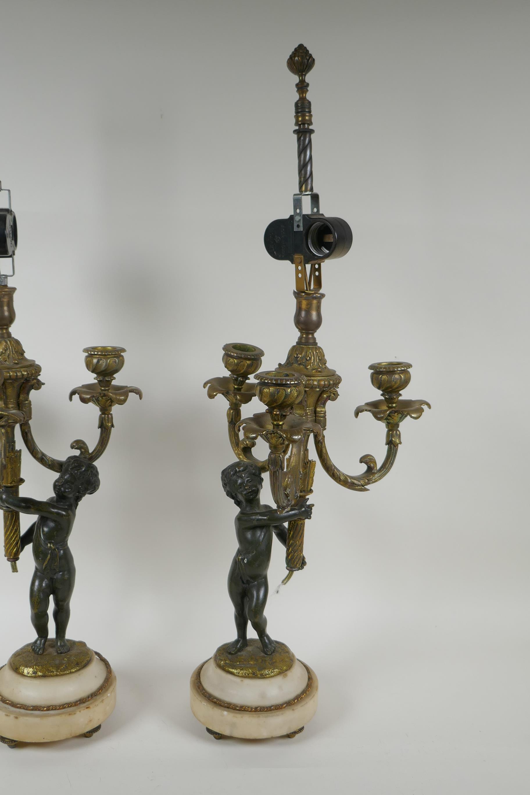 A pair of bronze and ormolu cherub three branch candlesticks converted to a lamp, 60cm high - Image 2 of 4