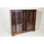 A mahogany bookcase with four sliding glass doors, 110 x 30 x 101cm