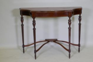 An inlaid mahogany console table with shaped top and four turned supports united by a shaped