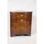 A bow fronted walnut corner cabinet, with two drawers over two cupboards, raised on bracket