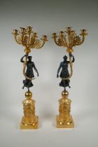 A pair of Regency style bronze and ormolu four branch candelabra in the form of classical women