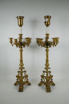 A pair of French ormolu five branch candlesticks on a tripod base with griffin decoration, the