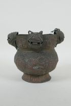 A Nepalese copper pot decorated with four tiger masks and repousse decoration of snakes and suns,