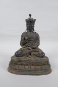 A Sino Tibetan bronze figure of Buddha with the remnants of lacquered patina, 25cm high