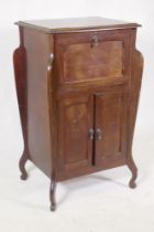 An early C20th Art Nouveau style mahogany music cabinet, with fall front and two cupboards, 55 x