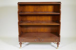 A Regency style mahogany waterfall bookcase with two drawers, raised on turned supports, 96 x 34 x