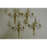 A set of four gilt brass two branch wall lamps, 34cm long