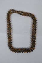 A tiger's eye bead necklace, 96cm long