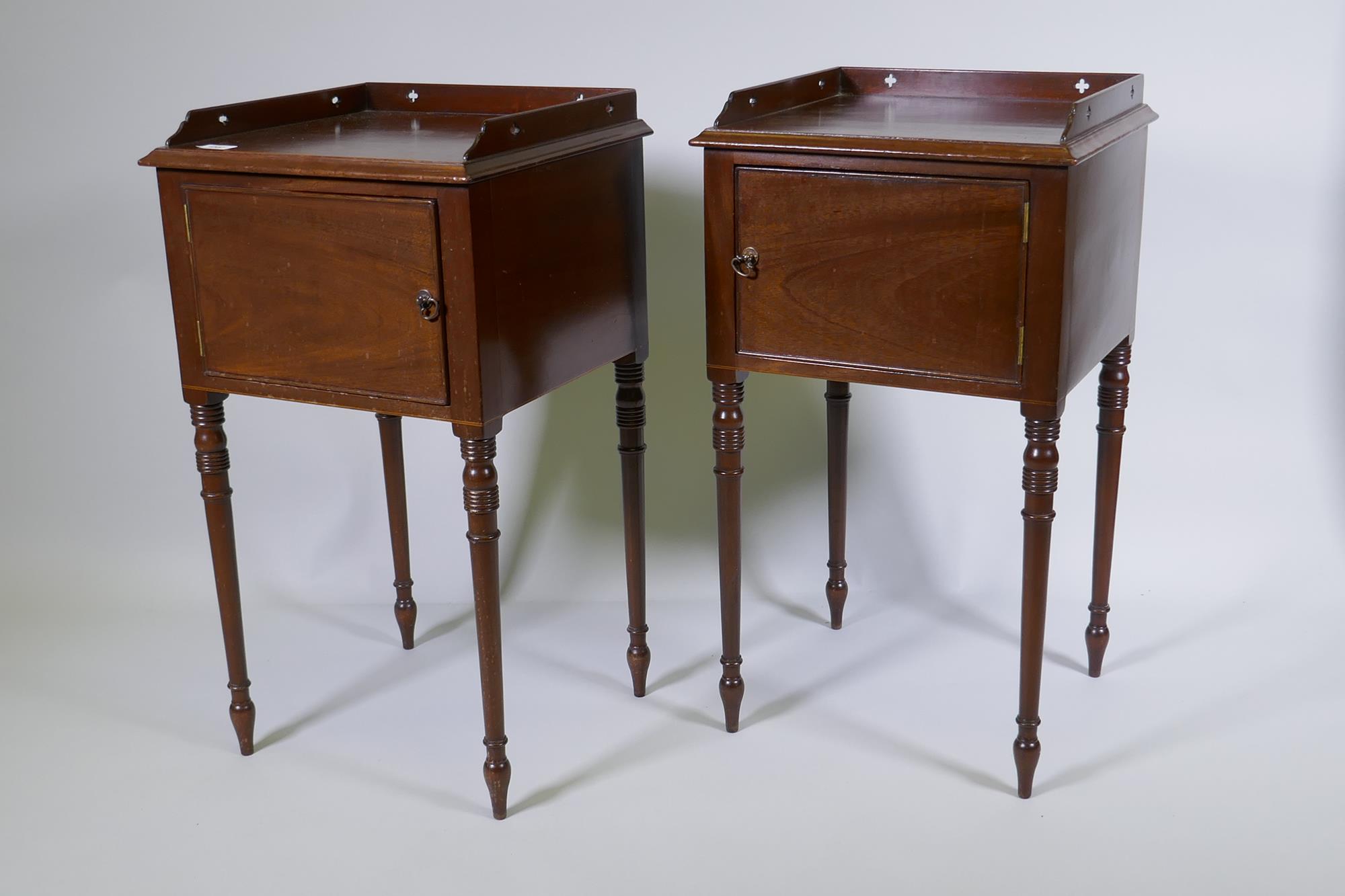 A pair of Georgian style mahogany pot cupboards with pierced three quarter gallery tops and single