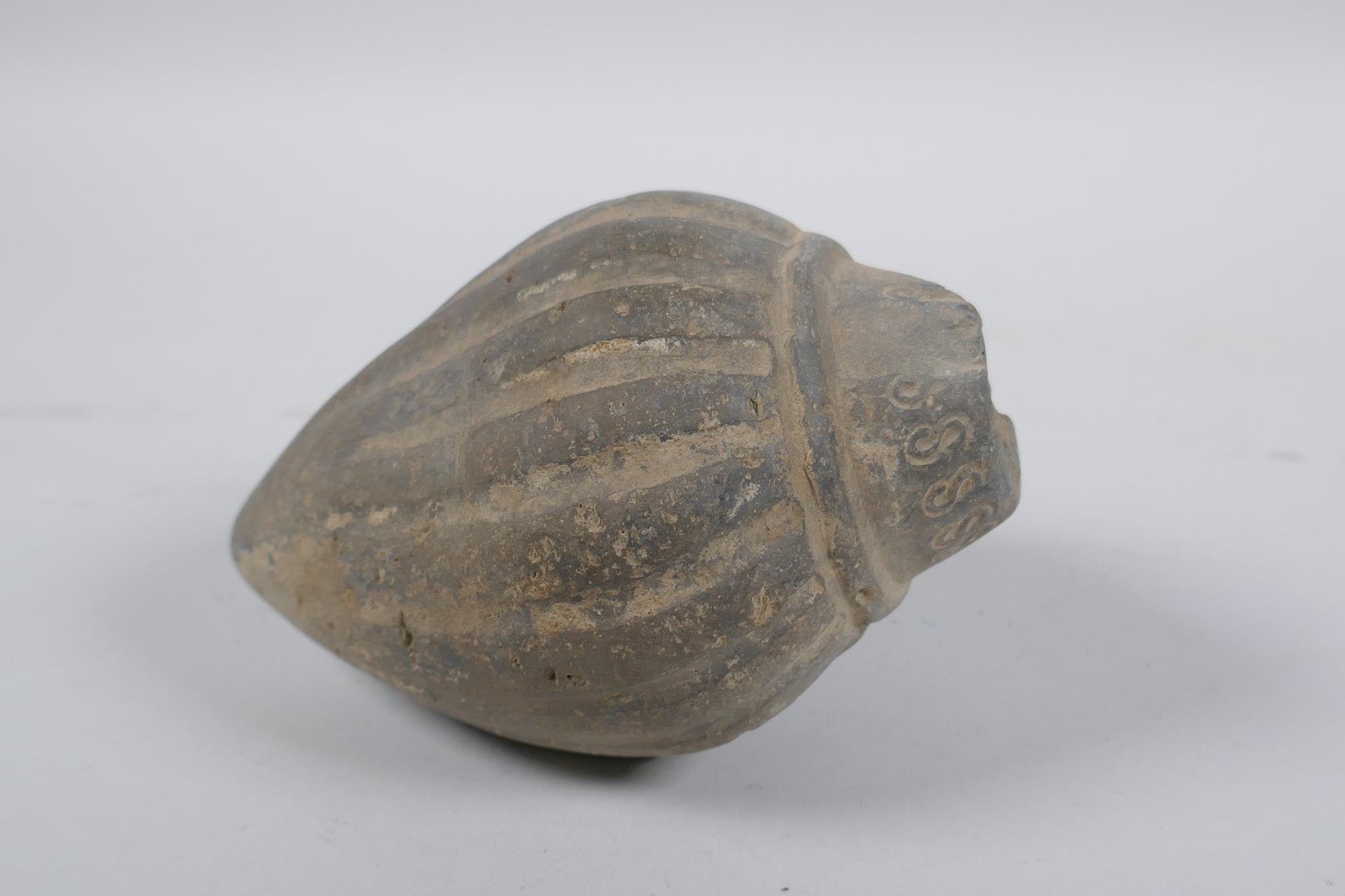 An early ceramic hand grenade/bomb, possibly C12th/C13th, with ribbed body and impressed motifs,