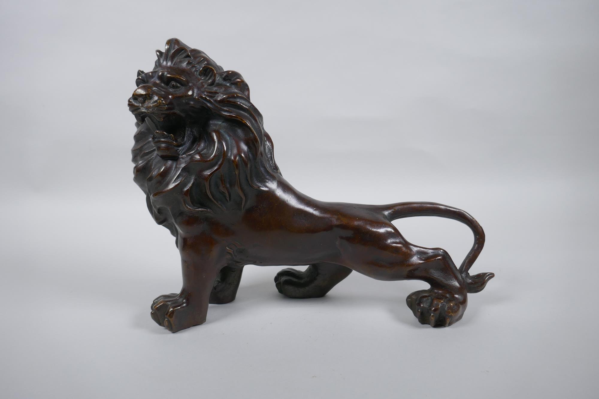 A filled bronze figure of a lion, 26cm long