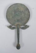 An antique bronze hand mirror with bird head decoration, possibly Etruscan, 23cm long