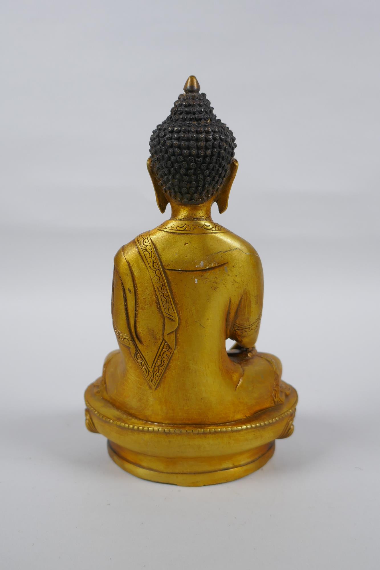 A Tibetan gilt metal Buddha seated in meditation, double vajra mark to base, 20cm high - Image 3 of 4