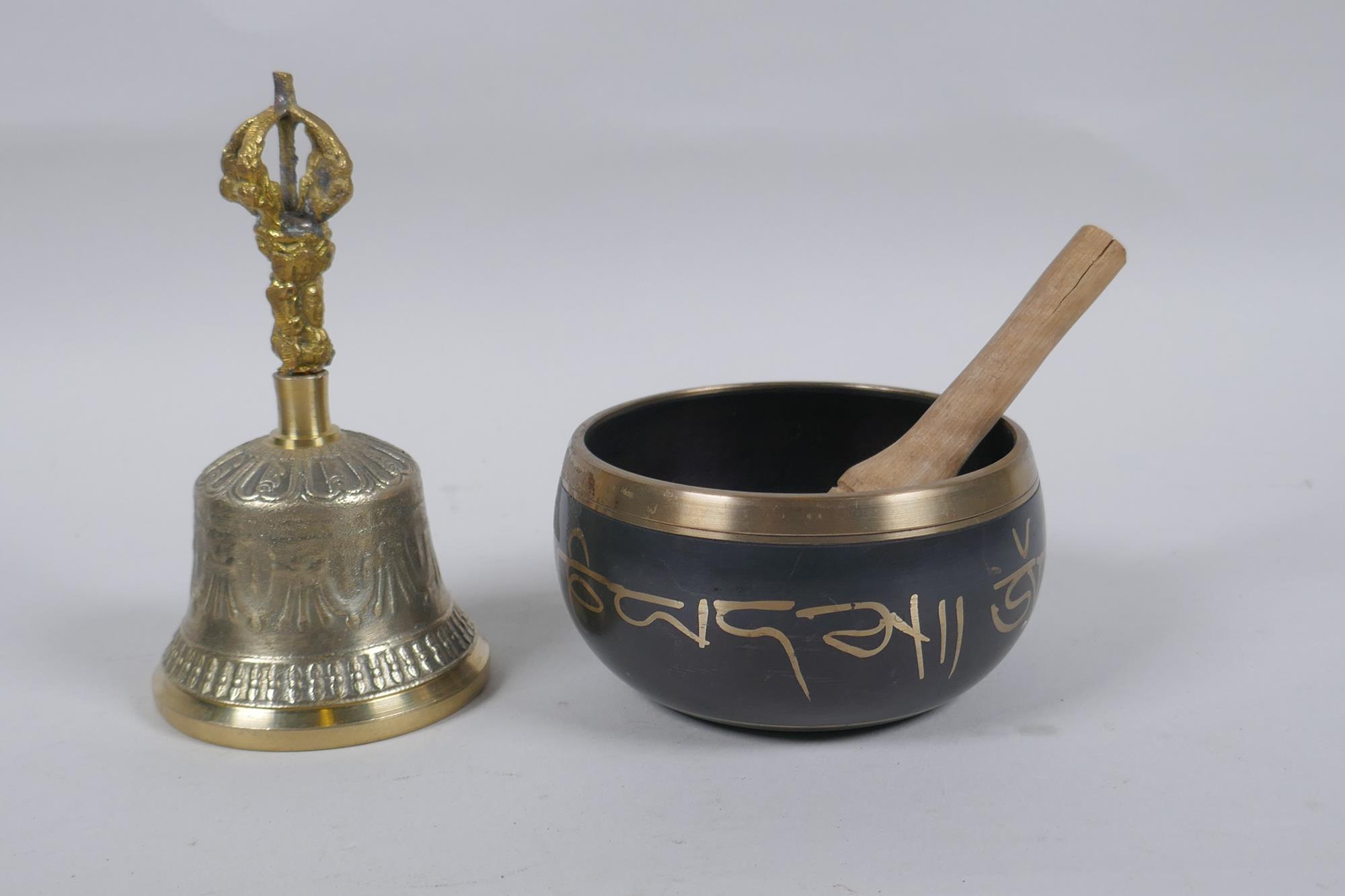 A Tibetan bronze singing bowl with script decoration and wood beater, and a brass ceremonial bell - Image 2 of 5