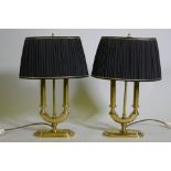 A pair of brass two branch table lamps with pleated shades, 49cm high with shades