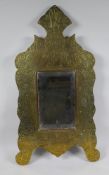 An Islamic brass and hardwood wall mirror with engraved script and scrolling decoration, 33 x 60cm