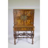 An early C20th figured walnut cocktail cabinet with brass mounts on stand, the interior with zinc