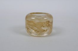 A Chinese rock crystal archers thumb ring with dragon decoration, 3cm diameter