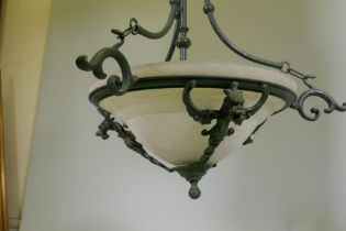 A pair of bronzed metal ceiling lamps with winged dragon decoration and etched glass shades, 65cm