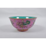 A Chinese polychrome porcelain rice bowl, decorated with temple lions on a pink field, inscription