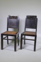 A pair of oriental lacquered wood side chairs with carved backs and woven cane seats
