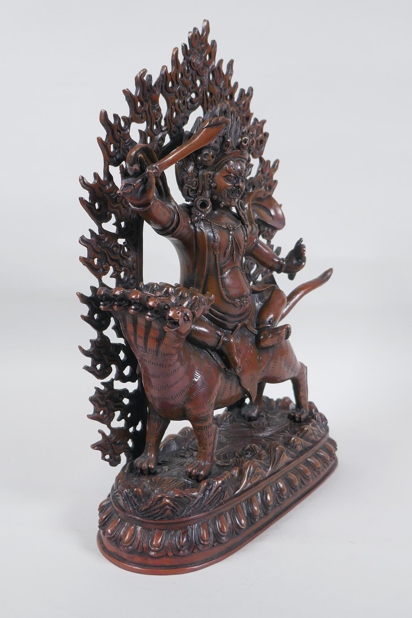 A Tibetan coppered bronze figure of a wrathful deity riding a mythical creature, double vajra mark - Image 3 of 6