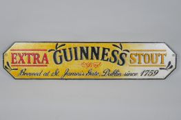 A painted cast iron 'Guinness Extra Stout' advertising sign, 57 x 13cm