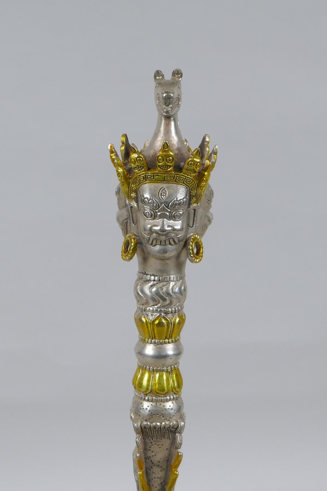 A Tibetan ceremonial metal phurba and stand with gilt metal highlights and wrathful deity masks to - Image 2 of 5