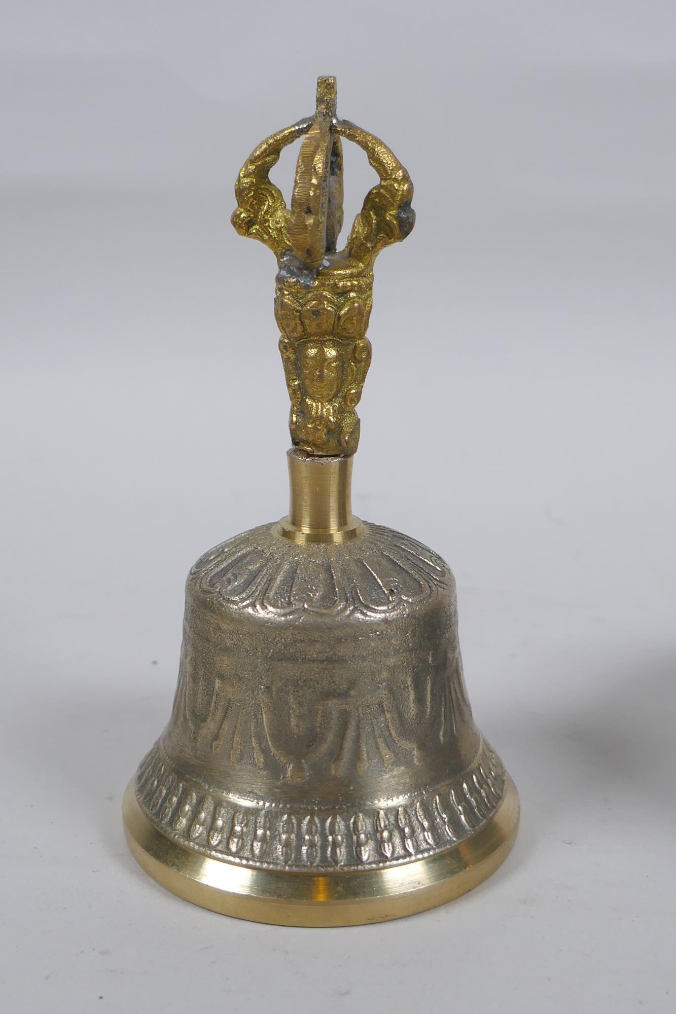 A Tibetan bronze singing bowl with script decoration and wood beater, and a brass ceremonial bell - Image 5 of 5