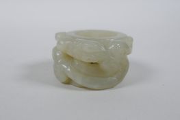 A Chinese grey jade archer's thumb ring with carved dragon decoration, 4.5cm diameter
