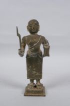 An antique South Indian bronze figure carrying Theyyam sword and shield, 19cm high