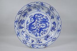 A Chinese blue and white porcelain charger with lobed rim, decorated with two dragons chasing a