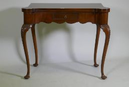 A George style walnut card table with shaped top and frieze, fitted with a single drawer, raised
