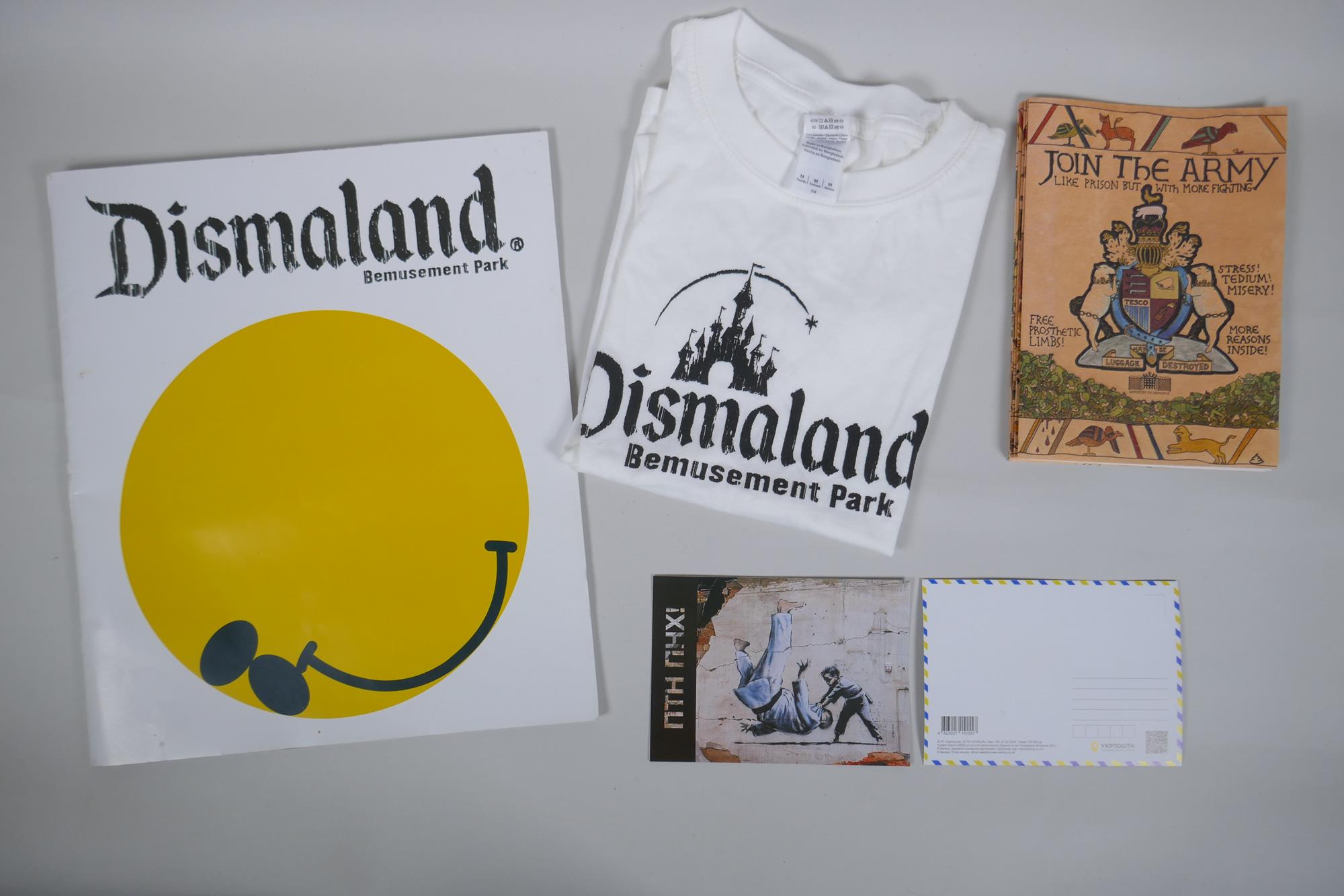 After Banksy, a Dismaland brochure, Dismaland T-shirt (child size M), and two FCK-PTN! postcards,