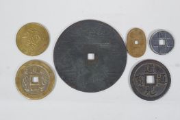 A large Chinese bronze pi-disc, and other smaller bronze pi-discs and tokens, largest 12cm diameter